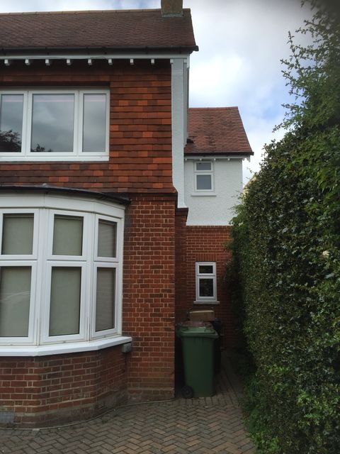 Bay window frames painted white on a red brick house