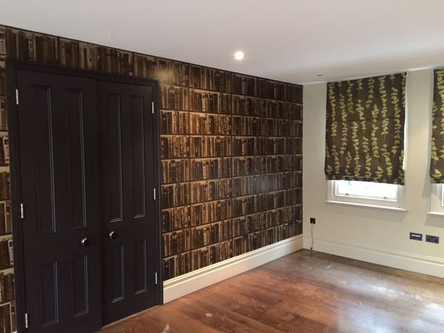 Feature wall in a dark wood-effect finish with navy double doors