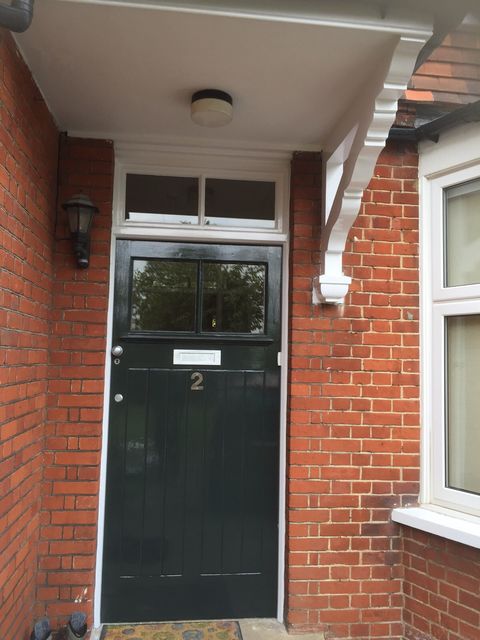 Front door and surround repainted on a red brick house