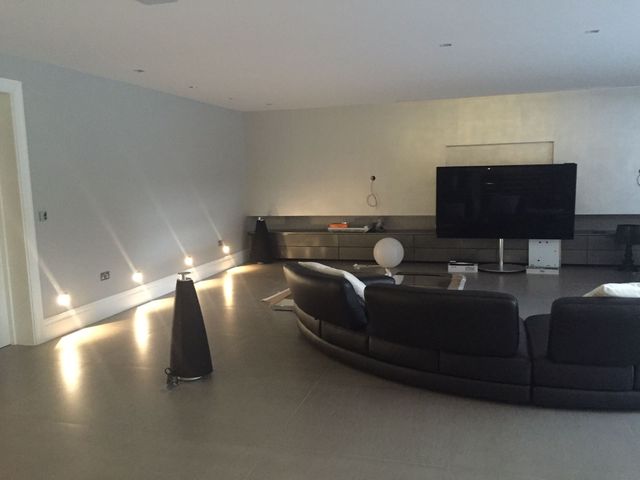 Lounge with a fitted media wall and lit shelving