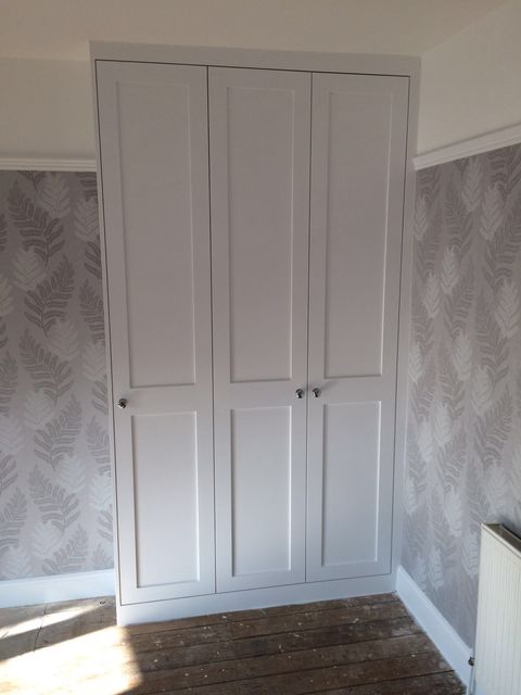 Patterned wallpaper beside a white fitted cupboard