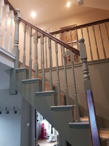 Grey painted staircase spindles, newel post and risers with a dark stained timber handrail