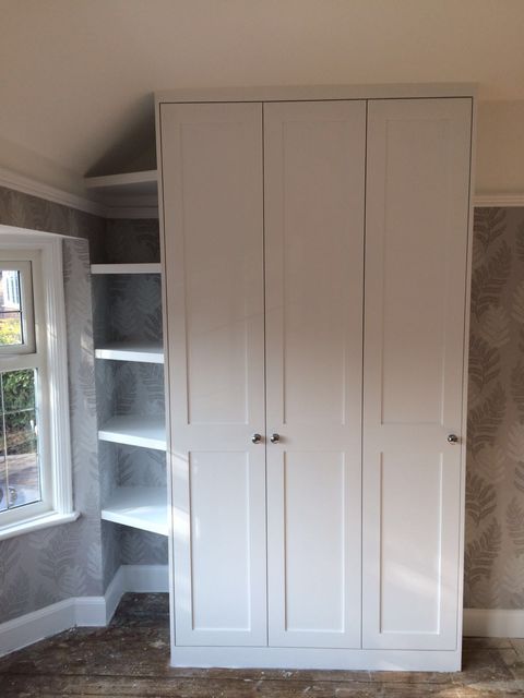 White fitted cupboard beside a window