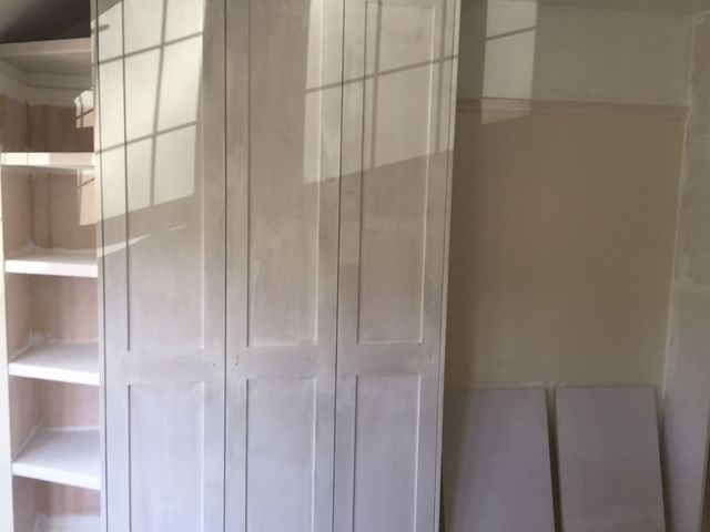White panelled doors on a fitted wardrobe, mid-installation