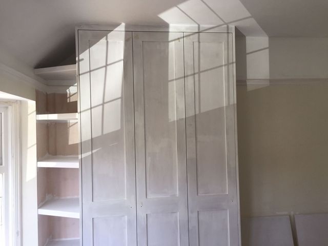 White panelled wardrobe doors under a dormer window